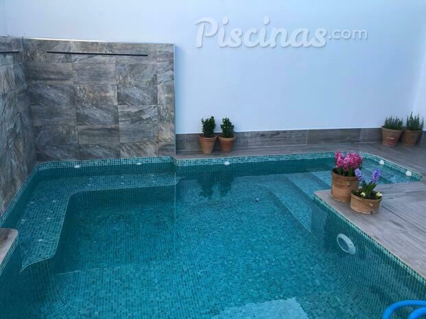 Piscina con cascada y banco tipo jacuzzi