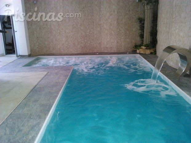 Piscina interior con hidromasaje y cascada inox