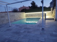 Piscinas climatizada con entorno Itaca Gris. Imagen nocturna.