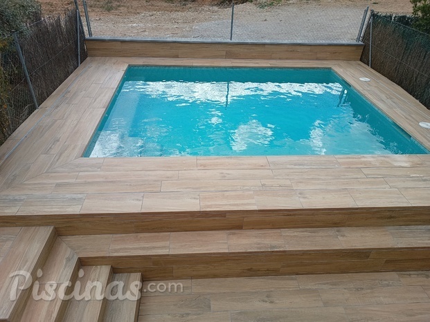 Piscina con entorno imitación madera.